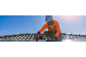 Man in werkkleding installeert zonnepanelen