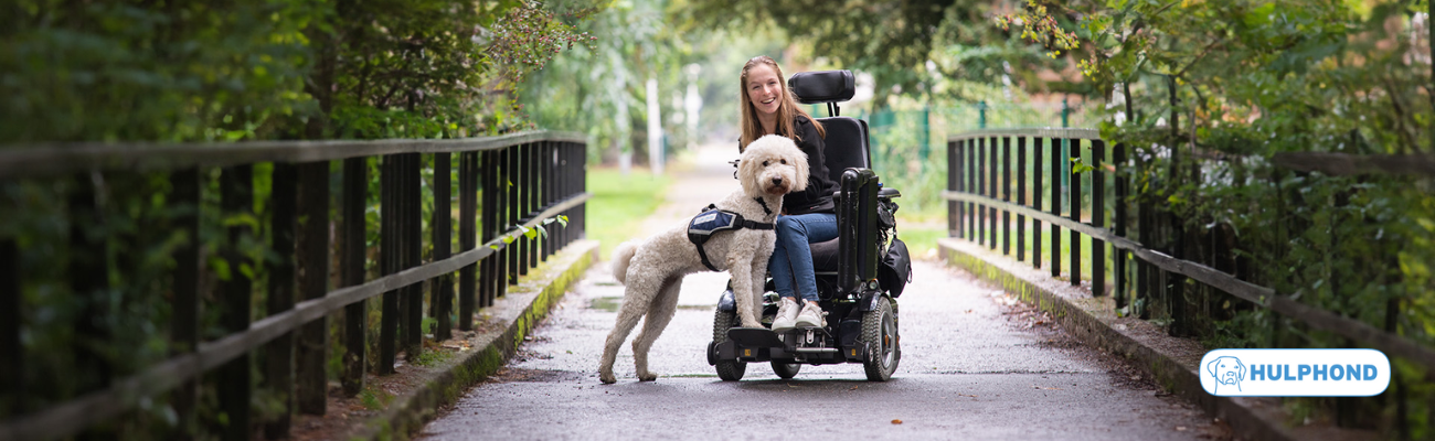 Vrouw in rolstoel samen met een hulphond 